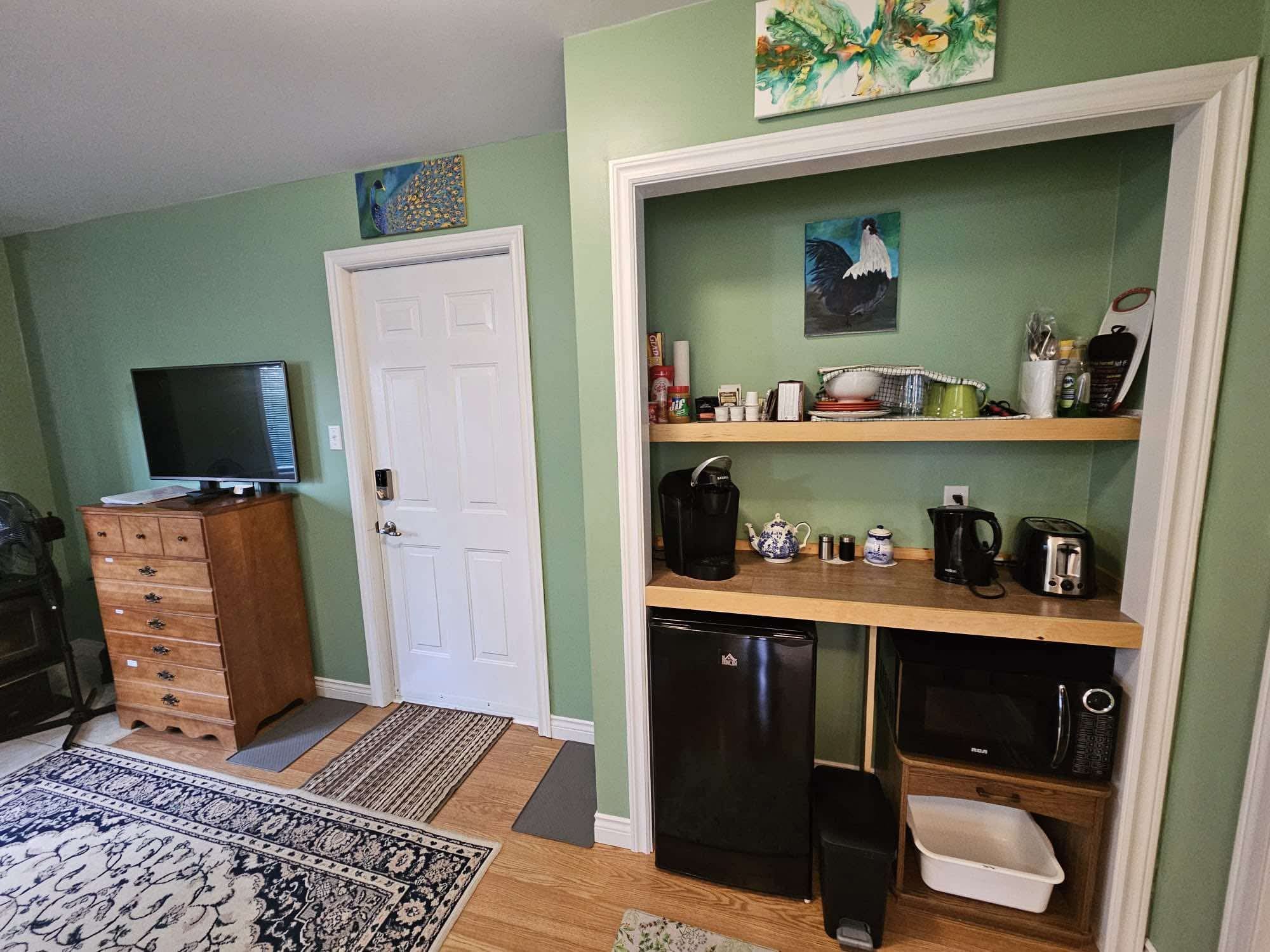 Kitchenette with coffee machine, kettle, toaster, microwave, mini fridge and open shelves